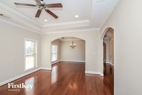 Mccalla house for rent - A spacious room with a ceiling fan and hardwood floors.