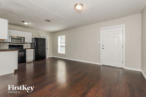 Orlando house for rent - A spacious empty room with wooden floors and a white door.