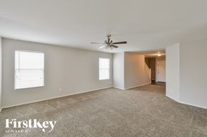 San Antonio house for rent - A spacious room with a carpeted floor, a ceiling fan, and a door leading to another room.