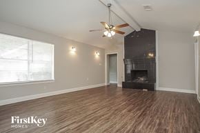 Houston house for rent - a living room with a fireplace and a ceiling fan