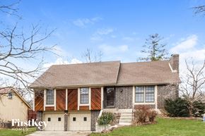 Kansas City house for rent - a brick house with wood trim and a garage