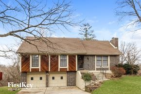 Kansas City house for rent - a brick house with wood siding and a garage