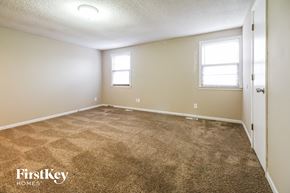 Kansas City house for rent - a bedroom with carpet and a door and window