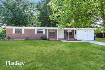 Jacksonville house for rent - a white and brick house with a lawn and trees