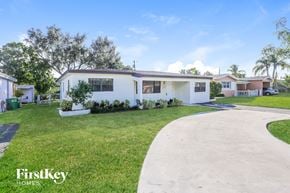 Miramar house for rent - a white house with a yard and a driveway