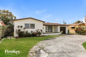 Miramar house for rent - a small white house with a driveway and a lawn