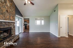 Jacksonville house for rent - A room with a stone fireplace and wooden floors.