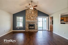 Jacksonville house for rent - A spacious living room with a fireplace and a ceiling fan.