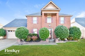 Memphis house for rent - a brick house with a garage and a lawn