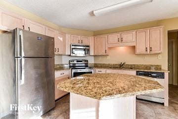 Memphis house for rent - a kitchen with white cabinets and a granite counter top