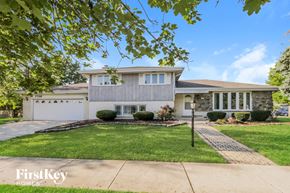 Orland Park house for rent - a white house with a lawn and a driveway