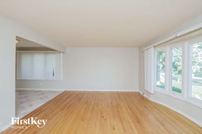 Orland Park house for rent - an empty living room with a wood floor and large windows