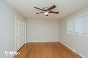 Orland Park house for rent - a bedroom with a ceiling fan and wood floors