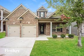 Fairburn house for rent - a brick house with two garage doors and a sidewalk