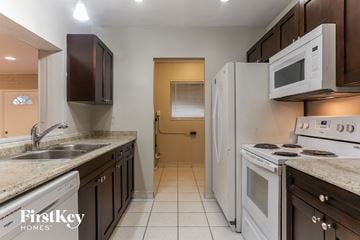Miramar house for rent - a kitchen with white appliances and brown cabinets