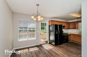 Winston house for rent - an empty kitchen with a black refrigerator and a window