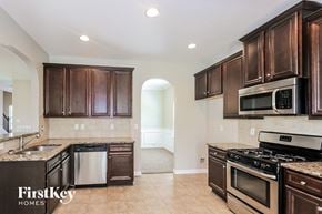 Atlanta house for rent - a kitchen with dark wood cabinets and stainless steel appliances