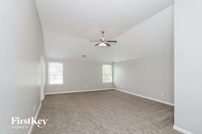 Atlanta house for rent - a bedroom with a ceiling fan and a carpet