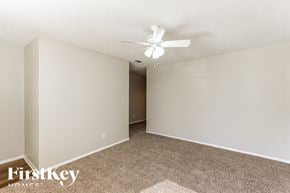 Dallas house for rent - the spacious living room with carpeting and a ceiling fan