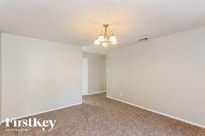Dallas house for rent - a bedroom with white walls and carpet and a chandelier