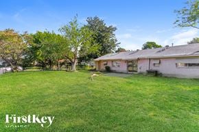 Dallas house for rent - a backyard with a house and a deer in the grass