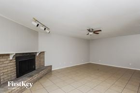 Fort Worth house for rent - a living room with a brick fireplace and a ceiling fan