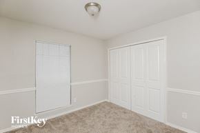 Fort Worth house for rent - a bedroom with two closets and a window and carpeting
