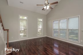 Charlotte house for rent - a living room with wood floors and a ceiling fan
