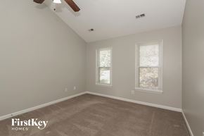 Charlotte house for rent - a bedroom with a carpeted floor and two windows