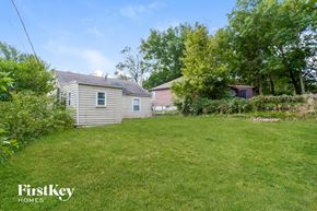 Kansas City house for rent - a backyard with a house and a yard with grass and trees