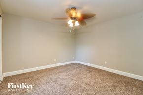 Tampa house for rent - A carpeted room with a ceiling fan and a FirstKey Homes logo.