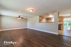 Tampa house for rent - A spacious room with wooden flooring and a ceiling fan.