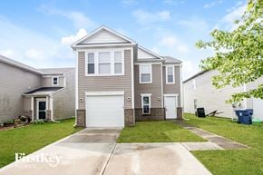 Camby house for rent - a beige house with two garage doors and a lawn