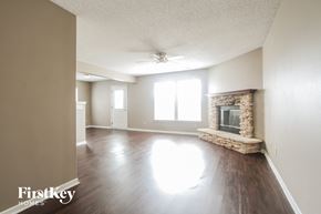 Camby house for rent - an empty living room with a fireplace and a ceiling fan