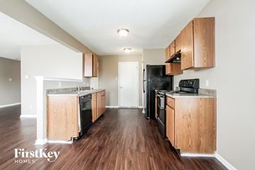 Camby house for rent - a kitchen with wood floors and wooden cabinets and black appliances