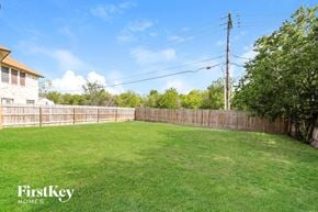 Converse house for rent - A backyard with a wooden fence and a grassy area.