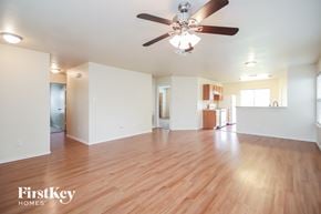 Cypress house for rent - an empty living room with wood floors and a ceiling fan