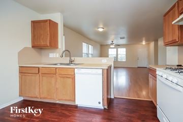 Cypress house for rent - a kitchen with wooden cabinets and a white dishwasher and a counter top