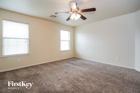 Cypress house for rent - a carpeted living room with a ceiling fan and two windows