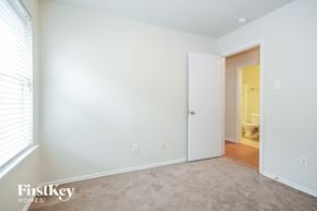 Cypress house for rent - a bedroom with white walls and a door to a bathroom