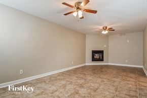 High Point house for rent - A room with a fireplace and a ceiling fan.