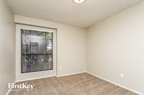 Rowlett house for rent - a bedroom with a large window and carpeted flooring