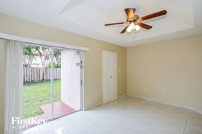 Hialeah house for rent - a living room with a sliding glass door and a ceiling fan