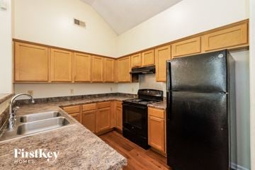 Memphis house for rent - A kitchen with wooden cabinets and a black refrigerator.