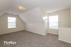 Memphis house for rent - A sparsely furnished room with a FirstKey Homes logo.