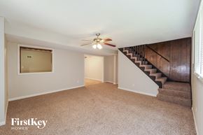 Kansas City house for rent - A spacious room with a staircase leading to the upper floor.
