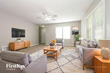 Raytown house for rent - A living room with a grey couch and a wooden coffee table.