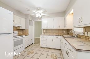 Raytown house for rent - A kitchen with white appliances and cabinets.