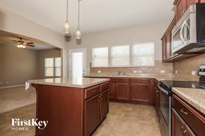 Matthews house for rent - a kitchen with granite counter tops and wooden cabinets
