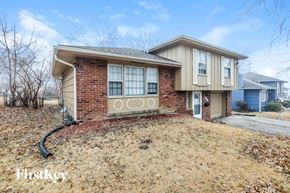 Kansas City house for rent - A house with a brick base and beige siding is for sale.